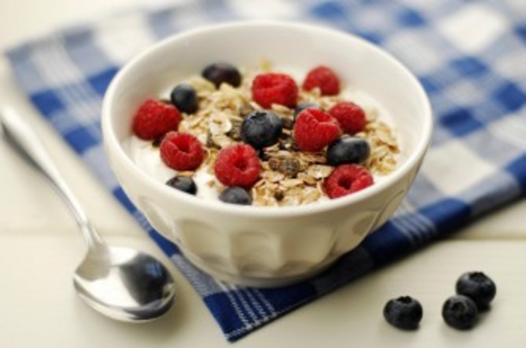 Muesli bowl with oatflakes,raisins,fruits and yoghurt. Selective focus.